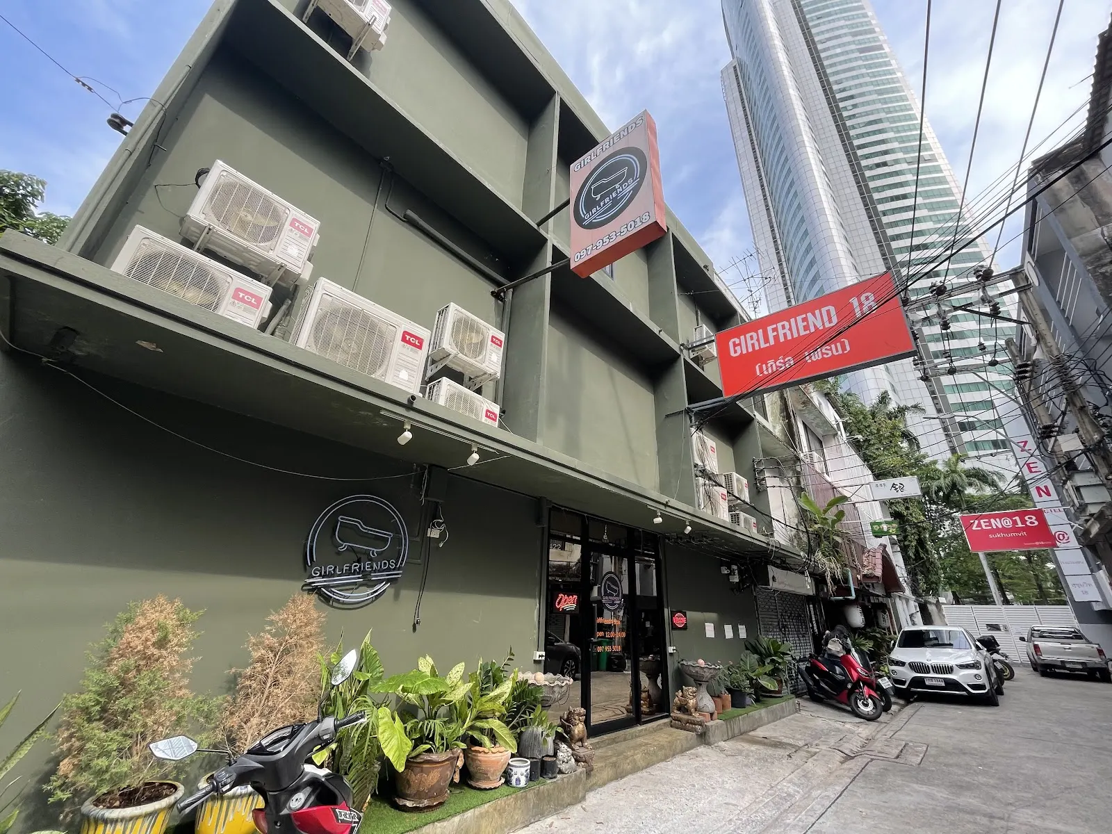 The green building on Soi 18 with the orange Girlfriend 18 sign and the round Girlfriends logo on the wall